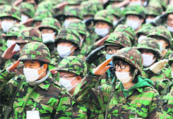 Soldiers wearing face masks to guard against H1N1 virus take part in a reserve forces training at a military training field in Seoul on Wednesday