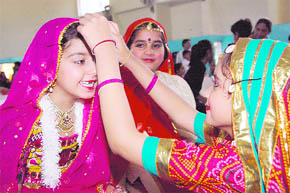 Girls help each other before participating in a dance competition held in Dehradun on Thursday.