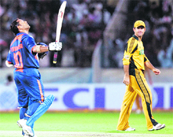 Sachin Tendulkar (L) acknowledges the crowd after scoring a century as Ricky Ponting watches during their fifth one-day international in Hyderabad 