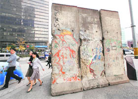 People walk past a section of the Berlin Wall displayed in Seoul on Thursday.