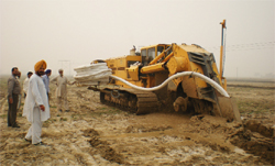 A huge trenching machine laying pipe to evacuate excess water in a water- logged field in village Pakki Tibbi in Muktsar district