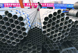 A labourer sits on steel pipes at a steel market in Hefei, Anhui province on Friday. China denounced as protectionist new US anti-dumping duties on steel pipes on Friday and called for Washington's swift recognition that it is a market economy, a week before a visit by US President Barack Obama