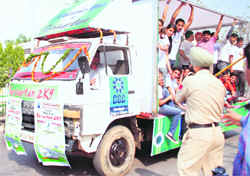 A traffic cop stops an overloaded vehicle of the Chandigarh Group of Colleges, Landran, during a road show at Mohali on Friday.