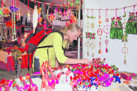 A foreigner chooses Rajsthani toys at a stall at Saras Mela in Dehradun on Friday.