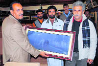 Mukhtar Ahmad hands over one of his landscape photographs to actor Naseeruddin Shah. 