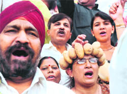 BJP activists wear vegetable garlands as they shout anti-government slogans at a protest against price rise in New Delhi on Saturday.