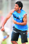 Indian captain Mahendra Singh Dhoni reacts after delivering a ball during a practice secession at the Nehru Stadium in Guwahati on Saturday.