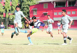 Players vie for the ball at a match at the Coca Cola Junior-Level Football Championship being held at Welham Boys' School in Dehradun on Sunday.
