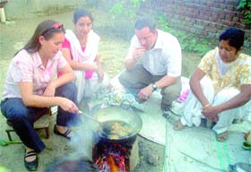 British teacher Sailly tries her hand at frying pakoras while her colleague Peter Gibbins looks