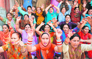 Members of the Anganwari Workers Association stage a protest in support of their demands in Jammu on Sunday. 