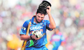 DOWN AND OUT: Indian cricketer Yuvraj Singh removes his helmet after being dismissed during the sixth (ODI) at the Nehru Stadium in Guwahati on Sunday.
