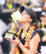 Aravane Rezai kisses her trophy after she won the WTA Bali Open tennis tournament beating Marion Bartoli at Nusa Dua, Bali on Sunday.