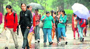 Girls enjoy rain at GCG-11 in Chandigarh on Monday.