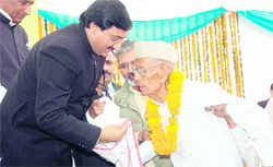 Uttarakhand Chief Minister Ramesh Pokhriyal Nishank honours a freedom fighter at a function held on state Foundation Day in Dehradun