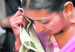 Gurmeet Kaur, an abandoned NRI bride, wipes her tears while narrating her <p>tragic story.