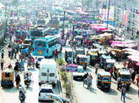 The auto-rickshaws outside the bus stand block the passage for commuters. 