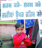A child holds a placard during a protest by BJP activists against price rise in Amritsar.