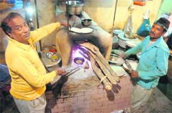  Cooks prepare chapaties on a traditional hearth at Mohan Vaishno Dhaba in Pucca Dunga, Jammu. 