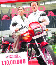 Pawan Munjal (L), managing director and CEO of Hero Honda Motors Limited, and Takanobu Ito, president and CEO of Honda Motor Company Japan, pose with the 11 millionth Splendor motorcycle at the Hero Honda plant in Gurgaon on Wednesday.