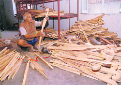 A worker gives shape to a hockey stick at a sports goods factory in Jalandhar