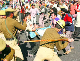Police personnel cane-charge protesting SRTC employees in Jammu on Thursday