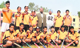 Members of Malwa Khalsa School hockey team with their coach and principal strike a pose in Ludhiana on Thursday.