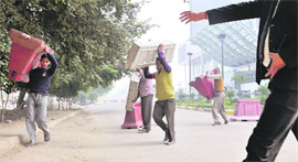 Labourers remove dividers placed by West End Mall on Ferozepur Road on Thursday.