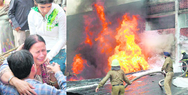 A relative of the owner of Gem Furniture showroom being pacified; and (above) firemen try to douse flames in Sector 7, Chandigarh, on Friday.