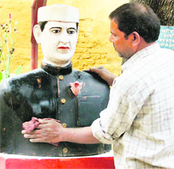 A worker cleans the bust of Jawaharlal Nehru at Nehru ward in old Dehradun jail  on Friday.