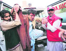 Volunteers help a person injured by a car bombing to get off from an ambulance as they arrive at a hospital in Peshawar on Friday. 