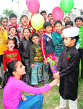 A girl gives flowers to a boy dressed as Chacha Nehru at Sector 22 in Chandigarh.
