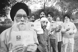 The riot victims show their red cards in Mohali 