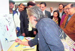 Prof Girijesh Pant, Vice-Chancellor of Doon University, looks on as artist S Pranam Singh signs a painting at the inauguration of Redeeming Masterstrokes at Doon University, Dehradun, on Friday