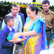 Uttarakhand Governor Margaret Alva distributes school uniforms to students in Dehradun on Saturday.