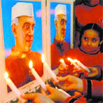 Children hold candles to pay tributes to Jawahar Lal Nehru on his birth anniversary in Amritsar on Saturday.