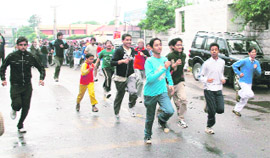Youth run along with schoolchildren during the Jammu Marathon on the occasion of Childrens Day in Gandhi Nagar on Saturday.
