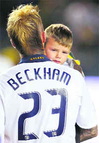 David Beckham carries his son Cruz off the field after celebrating the teams victory over Houston Dynamo during the Major League Soccer Western Conference Final in Carson on Friday. 