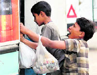 Children sell groundnuts at a local bus stand in Dehradun