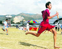 An athlete participates in a relay race at the District Athletics Meet in Dehradun on Sunday