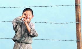 A boy reacts to the camera as he plays during a recess time at a school in Kamji village near Indo-Bhutan border