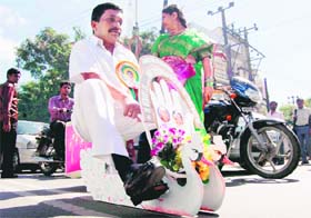 G Ashok, proprietor of a watch company, rides on the Swan Chariot, which he claims to have the smallest wheels in the world, in Hyderabad