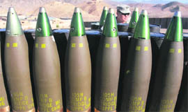 An US Army Sergeant waits behind 105mm artillery rounds before a fire mission at FOB Tillman, Afghanistan, on Sunday