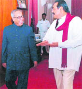 Sri Lankan President Mahinda Rajapakse talks with Finance Minister Pranab Mukherjee in Colombo on Sunday