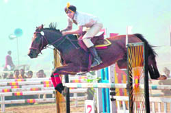 A participant jumps over a hurdle at a horse show in Chandigarh on Monday.