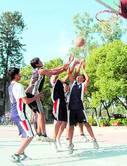 Players attempt a basket at the Senior Boys Council School Basketball Tournament in Dehradun on Monday