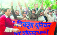 Members of the Auto Rickshaw Union protest in front of the Regional Transport Office in Dehradun on Monday