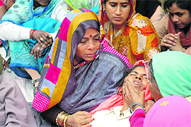Grieving family members of DIG OP Tanwar in Rathiwas, Nuh, on Tuesday.