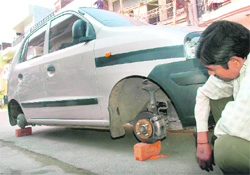 A man looks at a car after its tyres were stolen in Sector 41 of Chandigarh. 