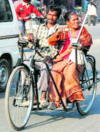 A couple teams up to run a tricycle in Dehradun on Wednesday