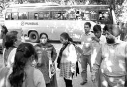 Harried passengers wait after the Punjab Roadways bus was brought to the Phase I police station in Mohali on Thursday.